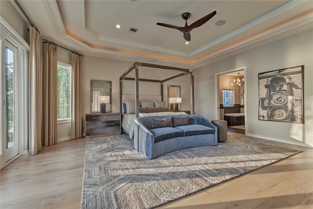Features include a trey ceiling, custom drapery and rich wood flooring. A 98" Samsung TV supported by Martin-Logan Surround Sound speakers will convey with the home. 