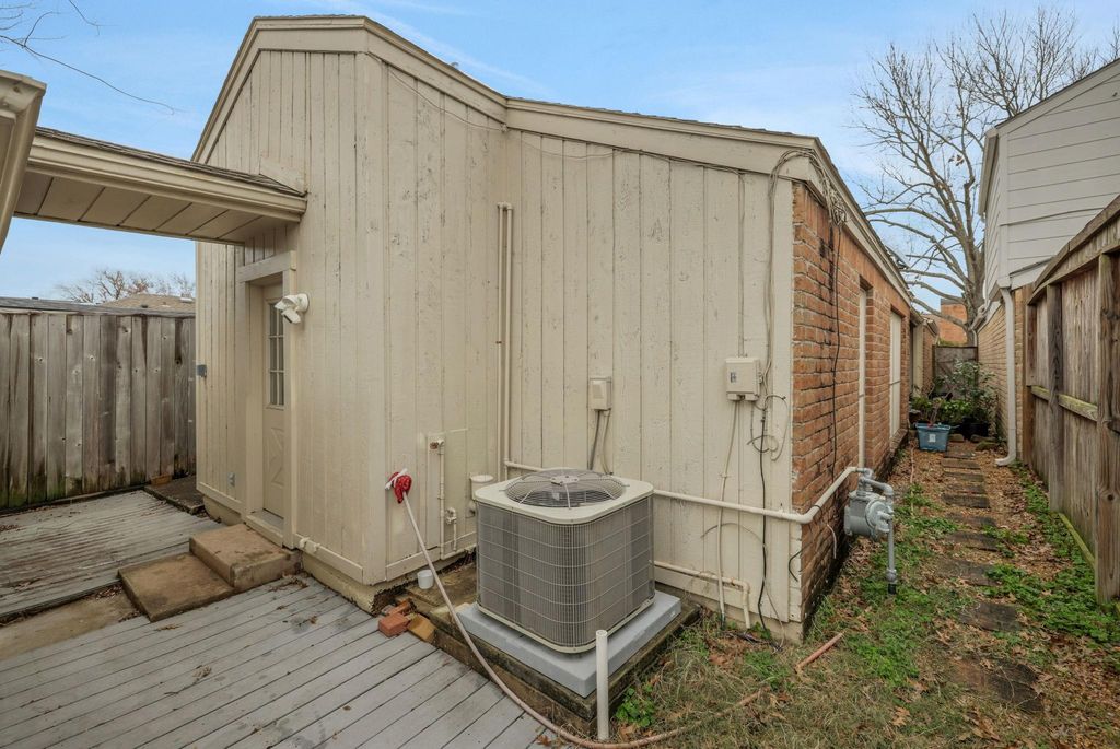 rear of home with covered walkway to the garage and a new AC